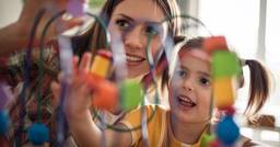 Early childhood educator playing with preschooler