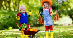 Two preschoolers gardening outdoors during a nature-based lesson. 