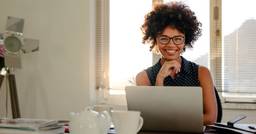 Childcare director smiling and sitting at computer 