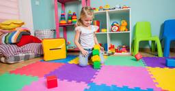 Preschooler playing with blocks on her first day at a new daycare in Texas