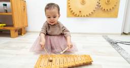 Toddler playing the xylophone in her classroom 
