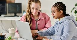 Two early childhood educators sitting at a computer together as they work together on professional development