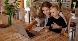 A preschooler and parent looking at a notification from their childcare center highlighting what they did that day.