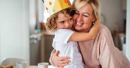 Preschooler wearing a crown and. hugging their teacher
