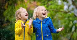 Two kindergarten children playing in the rain