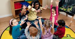 Teacher completing an activity with a group of preschoolers during circle time 