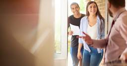 Childcare center owner welcoming two parents in for a school tour