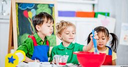 Three preschools working together to mix ingredients during cooking lesson.
