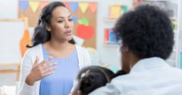 Preschool teacher speaking to parent during meeting