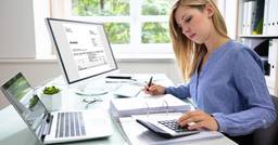 Childcare director organizing invoices and tax forms at her desk at work