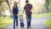 Parents holding hands walking down street with child