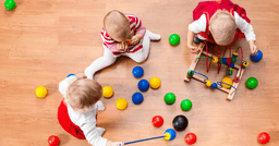 Group of toddlers freely playing after being given an invitation to play and prompted with materials