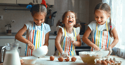 Three preschoolers working on cooking tasks together during cooking lesson. 