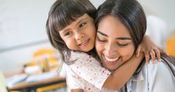 Preschooler and teacher hugging