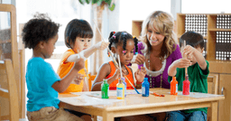 A group of preschoolers in an early childhood education setting playing together supervised by their teacher