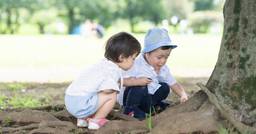 Two toddlers observing nature during nature-based outdoor learning time.