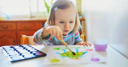 Preschooler painting spring artwork in the classroom