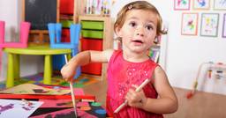 Toddler completing a process art activity in a classroom.
