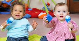 Two infants playing with musical shakers