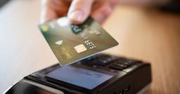 A childcare parent tapping their credit card on a credit card machine to pay for their childcare invoice. 
